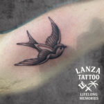 Black and grey swallow tattoo, created at Lanza Tattoo in Puerto del Carmen.