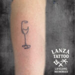 Minimalist wine glass tattoo, created at Lanza Tattoo in Puerto del Carmen.