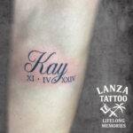 Elegant lettering tattoo with Roman numerals, created at Lanza Tattoo in Puerto del Carmen.