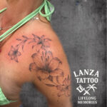 Fine line lily flower tattoo with delicate shading, created at Lanza Tattoo in Puerto del Carmen, Lanzarote