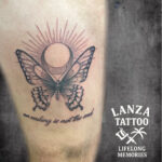 Black and grey butterfly tattoo with moon and sun design, created at Lanza Tattoo in Puerto del Carmen.