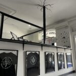 Lanza Tattoo studio interior with international T-shirts displayed on the wall in Puerto del Carmen.